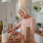 Smiling retired woman cooking while on a money diet