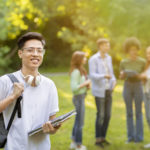 student holding notebooks