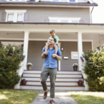 Father Giving son ride on shoulders outside home