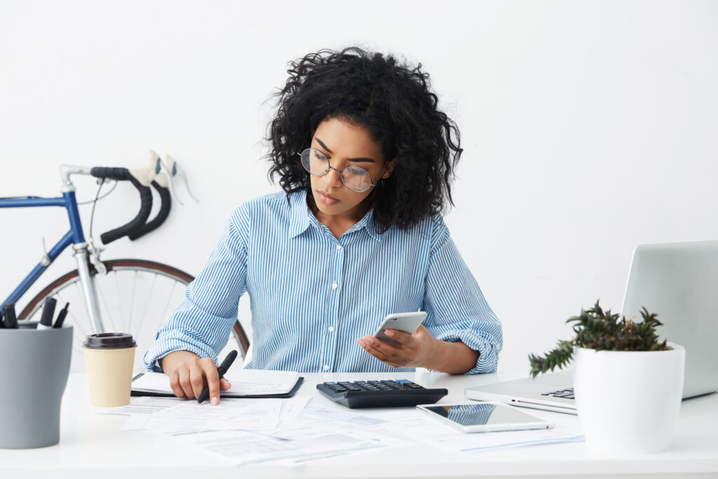 woman filing taxes with calculator and notepad