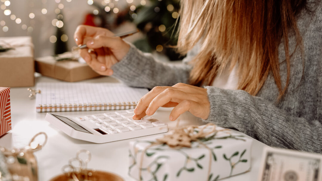 Woman doing holiday budget on calculator