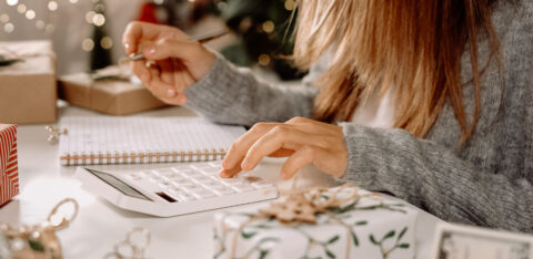 Woman doing holiday budget on calculator