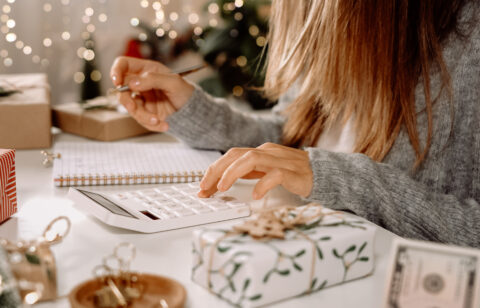 Woman doing holiday budget on calculator