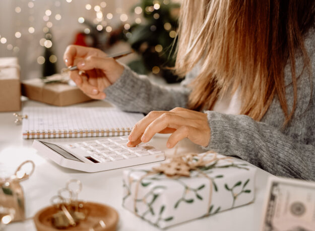 Woman doing holiday budget on calculator