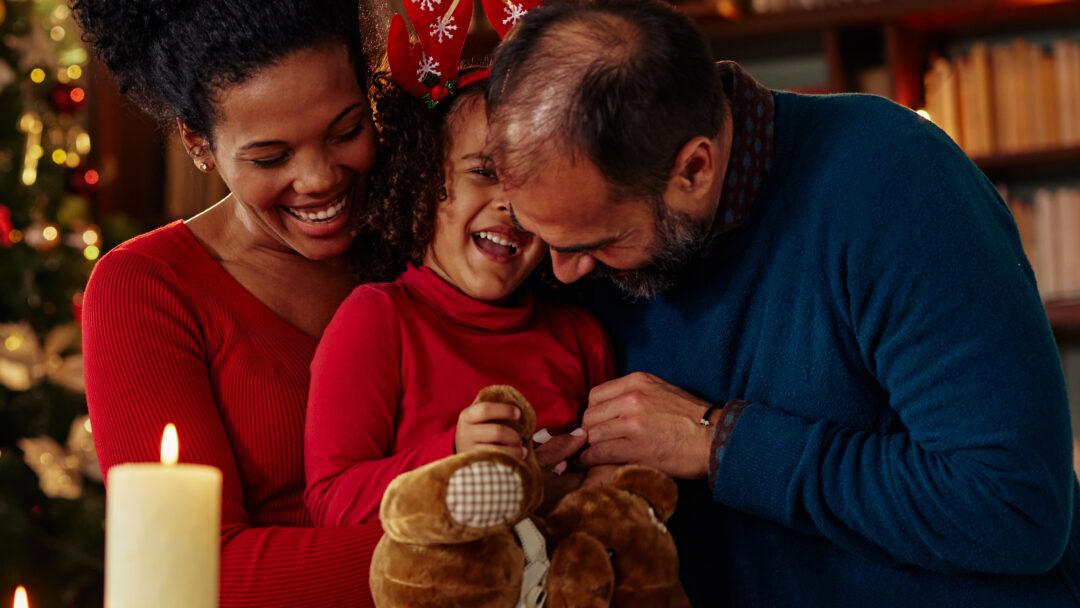 smiling child with parents with holiday decor in background