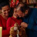 smiling child with parents with holiday decor in background