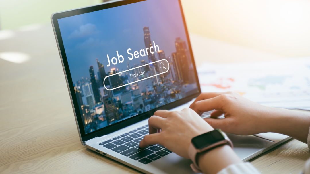 A job seeker browsing for opportunities online, with "Job Search" and a search bar displayed on a laptop screen.