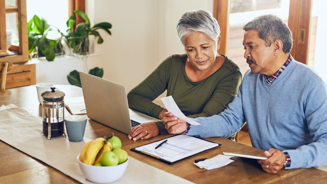 Older couple looks at bills and budget worksheet