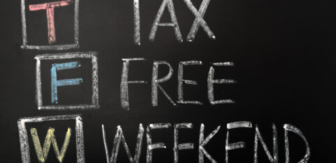 A chalkboard sign displaying "Tax-Free Weekend" in bold, hand-drawn lettering